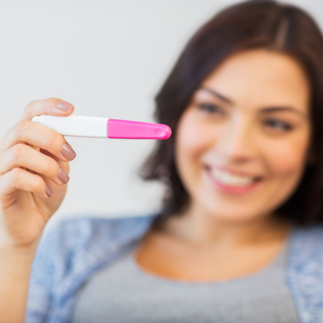 Woman smiling at pregnancy test